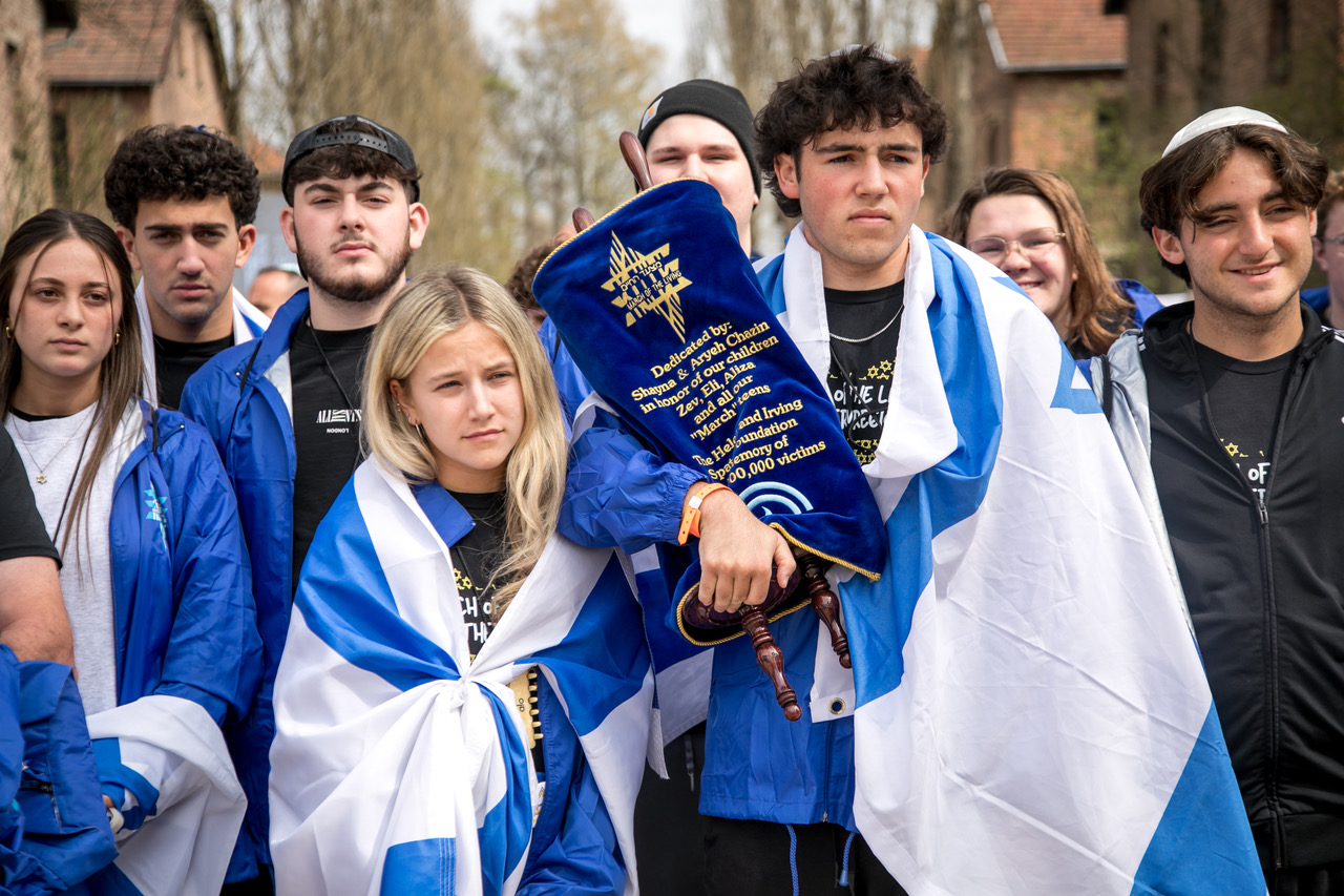 Participants carrying a Torah scroll at Auschwitz