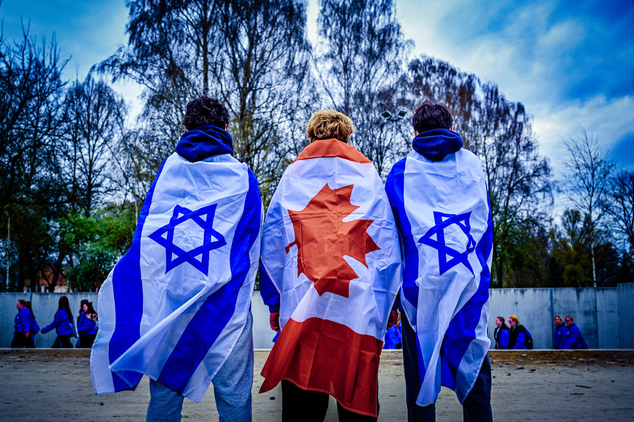 Three participants draped in Israeli and Canadian flags