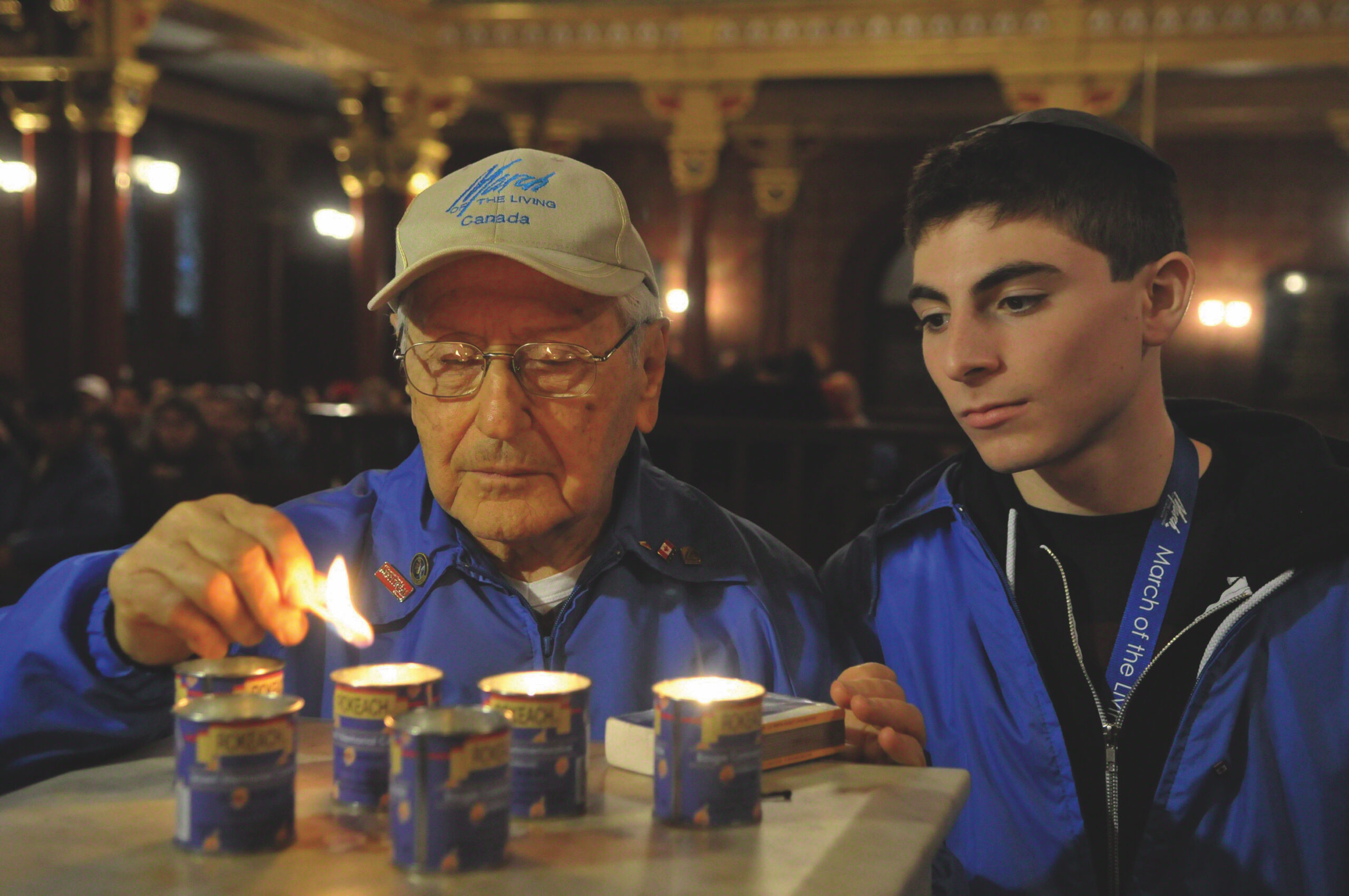 Ted Bolgar lighting a memorial candle beside a March of the Living student