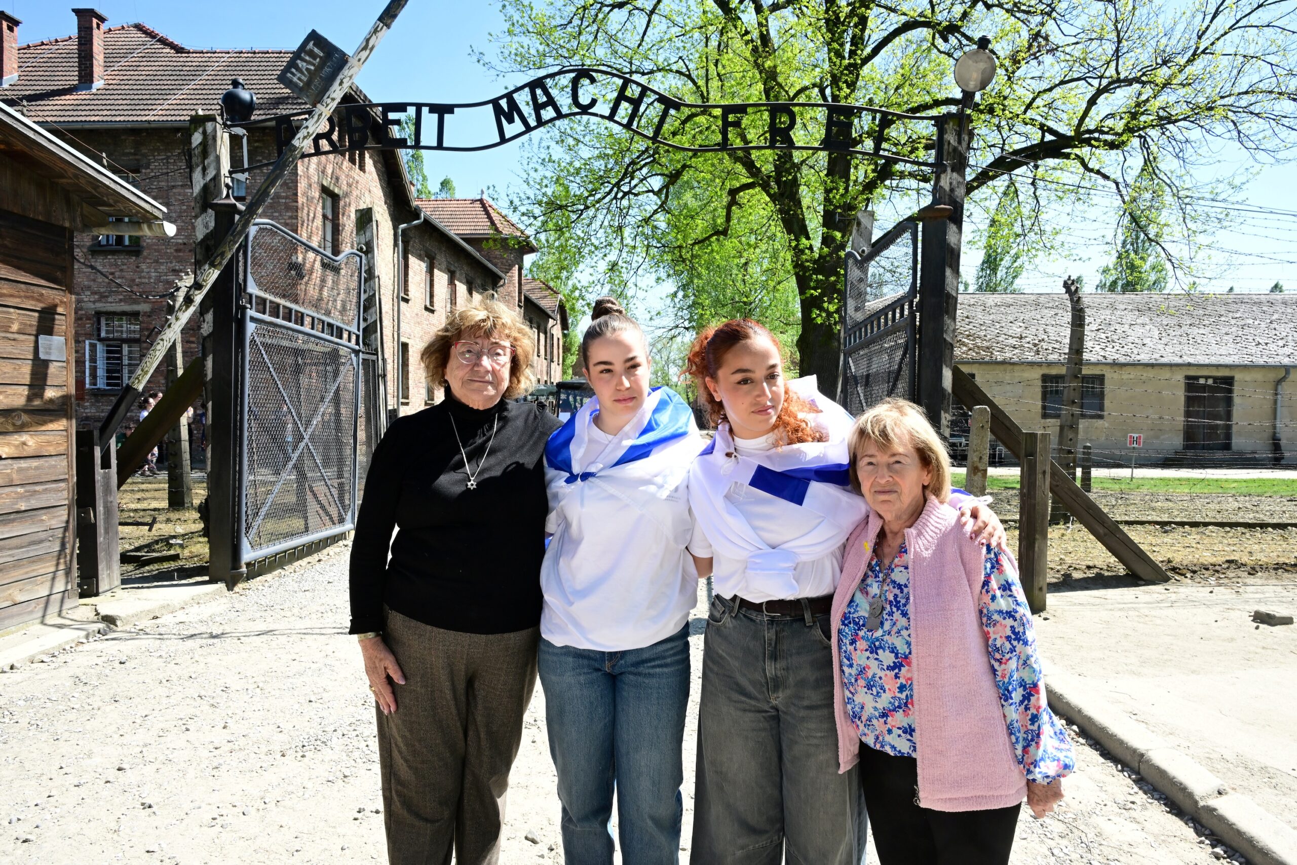 Holocaust survivors Irene Shashar and Gita Kaufman with Agam Berger and Ori Megidish at the Auschwitz gate