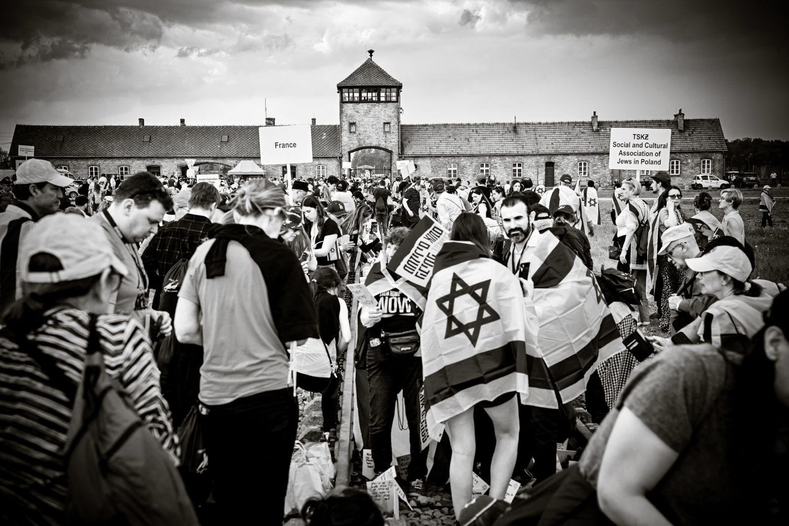 Marchers with Israeli flags walking toward the gate at Birkenau