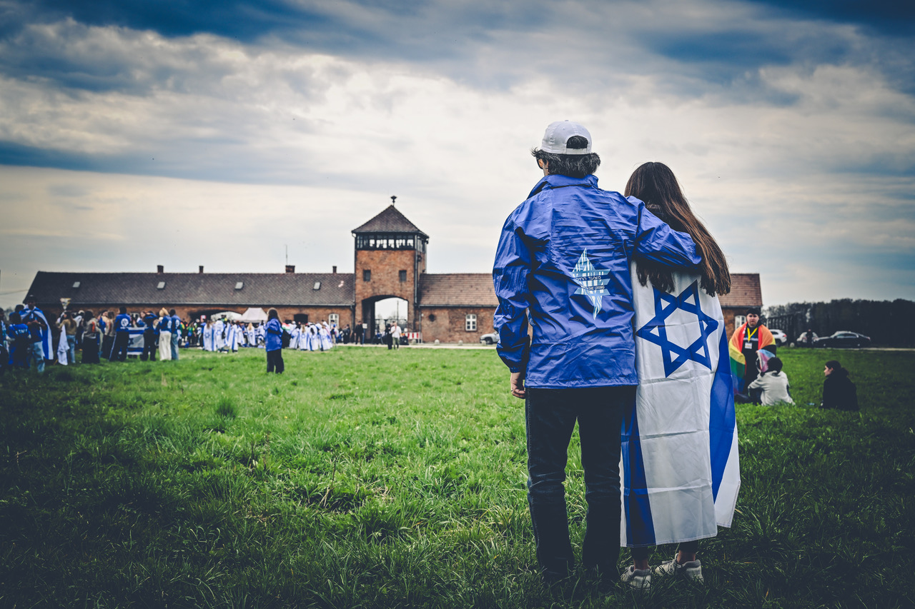Two participants looking towards the gate at Birkenau