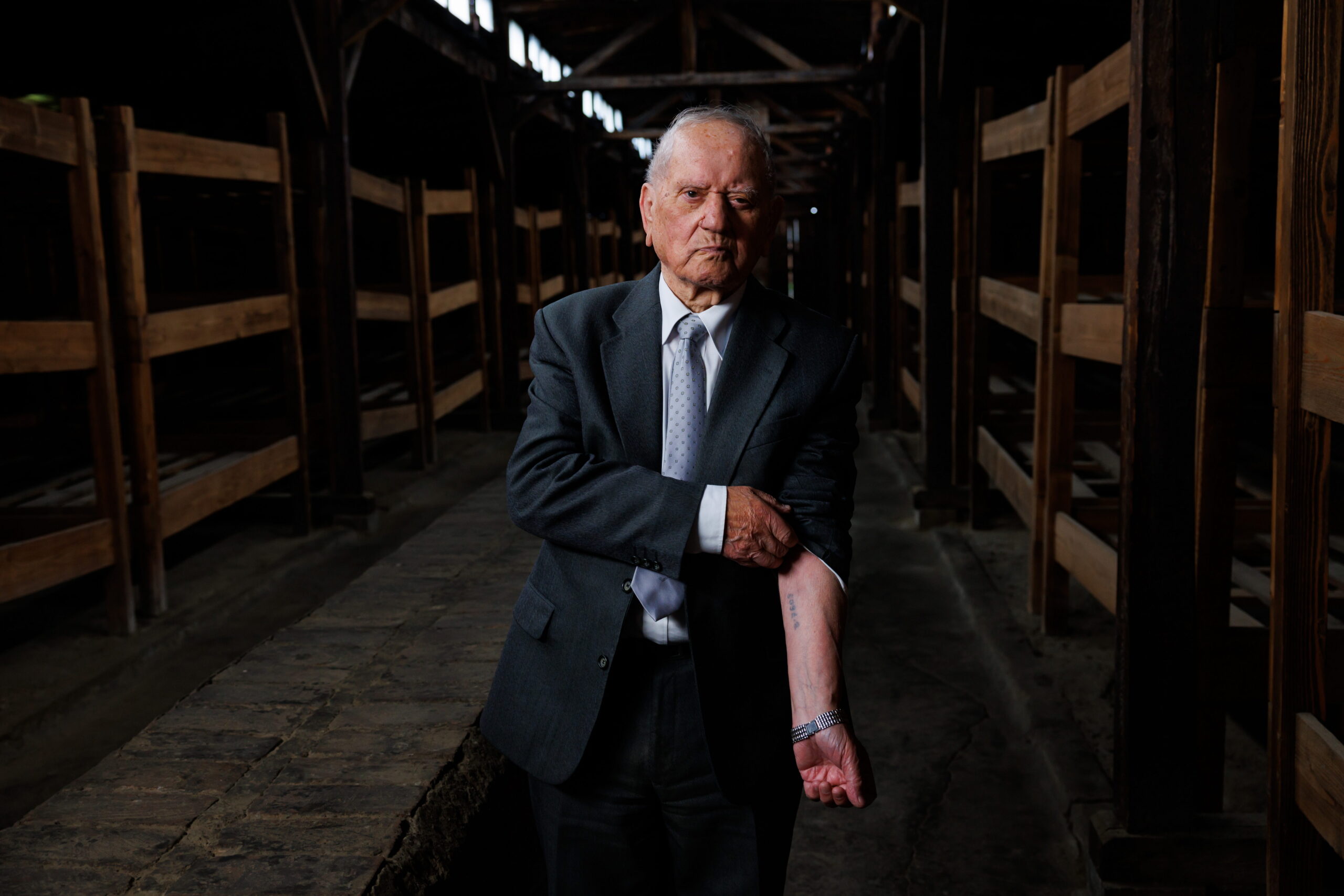 April 18th, 2023 - Auschwitz, Poland. 95yo Holocaust survivor Arek (prisoner number B7608) was born in Poland. When the WW2 broke he was forced to flee to Lodz. Arek's family was sent to the concentration camp where they were murdered. Arek was then sent to Auschwitz together with 185 orphans, He was 14 at that time. Only 40 people out of 5000 from Arek's city survived the Holocaust. Arek's grand-daughter works at the White House. Arek is photographed beside the bunk beds in the Auschwitz Birkenau concentration camp where he slept while he was a prisoner of the Germans in World War 2. Today Arek lives in Leeds, England. (Ziv Koren/Polaris)